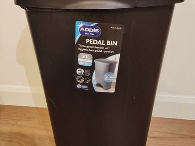 A tall black pedal trash can with a closed lid (item type photo, not the exact product)