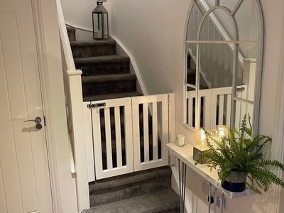 A white safety gate across the bottom of a staircase (item type photo, not the exact product)