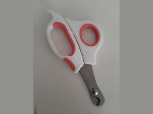 Scissor-style cat nail clipper with red and white handles