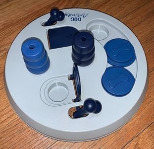 Interactive dog treat puzzle toy on a wooden floor (item type photo, not the exact product)